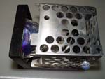 Gently replace the metal caging/houseing